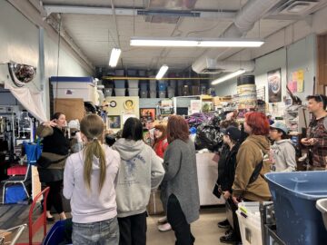 students learning about how to manage goods coming into second hand store Positive Apparel 